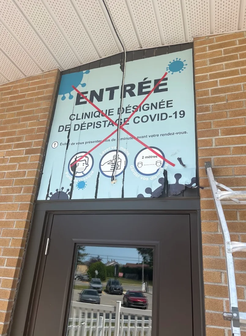 Ancien affichage de clinique de dépistage sur un bâtiment institutionnel
